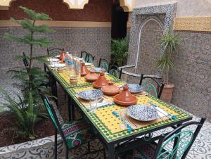 a table with plates and dishes on it on a patio at Riad Ingbiwn N'Tiznit in Tiznit