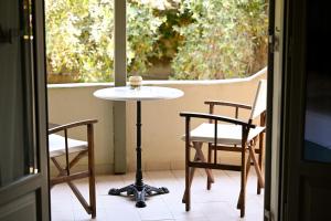 a table and chairs on a balcony with a window at Aggelos Grand in Koukounaries