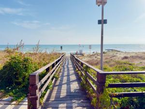 a boardwalk to the beach with the ocean in the background at Meduse Seafront - Attico al Mare in Torvaianica