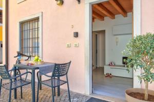 a patio with a table and chairs and a house at Domus Al Concilio in Trento