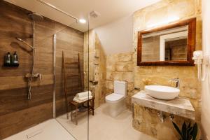 a bathroom with a sink and a toilet and a shower at Nelsonhaus -Boutique Guesthouse in Cospicua