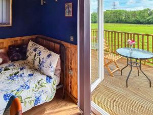 a bedroom with a bed and a table on a balcony at Badgers - Uk46750 in Herstmonceux +10 photos