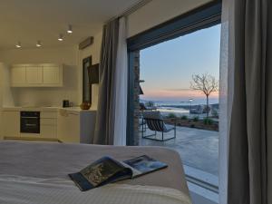 a bedroom with a bed and a large window with a view at Olithos Villas in Krotiri