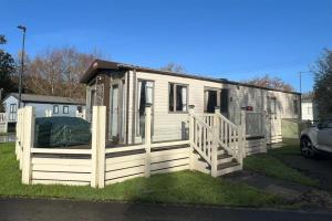 a small white house with a wooden fence at Poppy in Ferndown