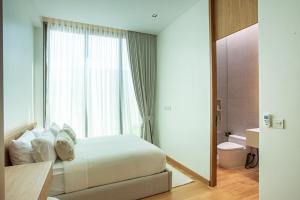 a bedroom with a white bed and a window at OASIS Luxury Private Villa in Ban Phru Champa +20 photos
