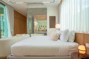 a bedroom with a large white bed and a couch at OASIS Luxury Private Villa in Ban Phru Champa
