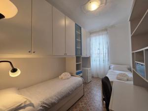 a bedroom with two beds and a desk with a lamp at Poesia - By Ligooria in Pietra Ligure