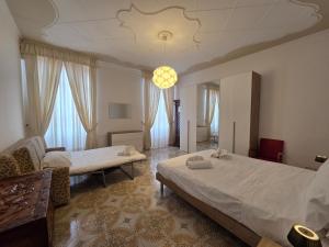 a bedroom with two beds and a chandelier at Poesia - By Ligooria in Pietra Ligure +7 photos