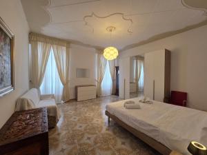 a bedroom with a large bed and a chandelier at Poesia - By Ligooria in Pietra Ligure
