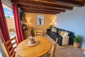 a living room with a table and a couch at Maison Monbazillac avec piscine 2-4 pax in Monbazillac