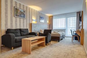 ein Wohnzimmer mit Sofa und Tisch in der Unterkunft Hotel Wilna in Erfurt