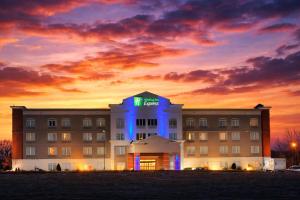 a hotel with a lit up sign in front of it at Holiday Inn Express Syracuse-Fairgrounds by IHG in Warners