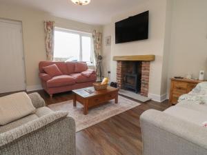 a living room with a couch and a fireplace at Wardenlea in Preston