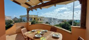 a table on a balcony with a view of a city at 023 e 024 Tulipano di SalentoInVacanzaCOM in Torre Pali