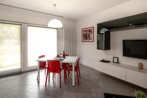 a dining room with a white table and red chairs at Il Sogno di Elisa in Trivignano