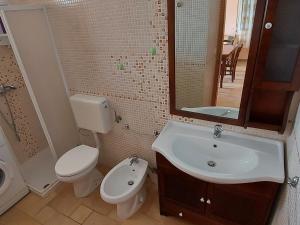 a bathroom with a toilet and a sink and a mirror at 023 e 024 Tulipano di SalentoInVacanzaCOM in Torre Pali