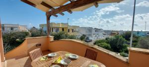 a table on a balcony with a view of a street at 023 e 024 Tulipano di SalentoInVacanzaCOM in Torre Pali