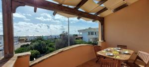 a balcony with a table and a large window at 023 e 024 Tulipano di SalentoInVacanzaCOM in Torre Pali +59 photos