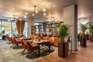 a restaurant with tables and chairs in a room at Jurmala Spa Hotel in Jūrmala