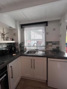 a kitchen with a sink and a window at Foretop Cottage, Staithes in Staithes