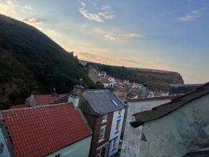a view of a town with houses and a mountain at Foretop Cottage, Staithes in Staithes