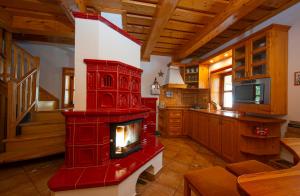 a living room with a red fireplace in a kitchen at Pinius by Hotel Pieris in Pribylina