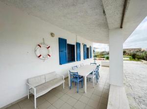 a patio with a table and chairs and a clock at Villa Marzamemi in Marzamemi