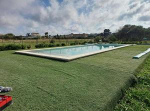a swimming pool in the middle of a grass field at Villa Marzamemi in Marzamemi +11 photos