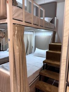 a bedroom with two bunk beds and a staircase at Rajal Dormitory in Indore