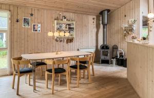 a dining room with a table and chairs and a stove at Holiday Home Ingerslevvej Gørlev Vi in Gørlev