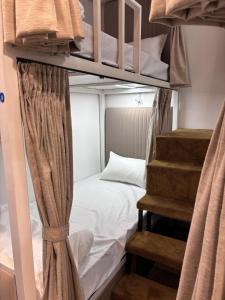 a bunk bed with a staircase in a room at Rajal Dormitory in Indore +7 photos
