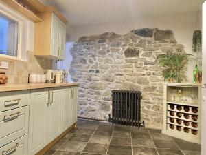 a kitchen with a stone wall with a fireplace at Bronafon in Rhyl +14 photos