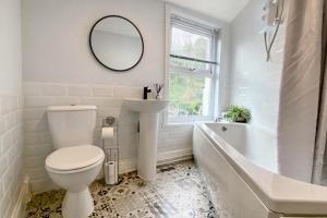 a bathroom with a toilet and a tub and a sink at Bronafon in Rhyl