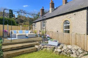 a patio with a couch on a wooden deck at Bronafon in Rhyl