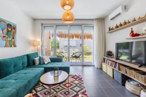 a living room with a green couch and a tv at Talea Joyful Stay by PikHost in Lezhë