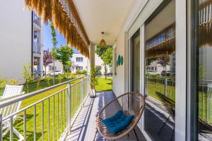 a porch with a wicker chair on a balcony at Talea Joyful Stay by PikHost in Lezhë