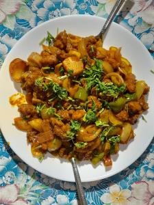 a plate of food on a table with two forks at Beach Times Resort in Kottakupam