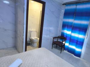 a bedroom with a bed and a toilet and a chair at Casa Salma in Seville