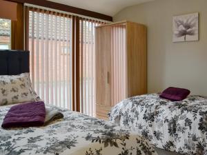a bedroom with two beds and a window at Koi Keep - Ukc1909 in Doddington +6 photos
