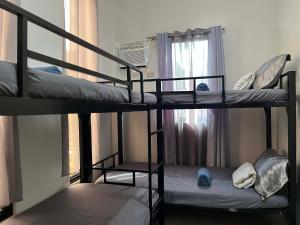two bunk beds in a room with a window at Baldonado Transient Homestay in San Isidro