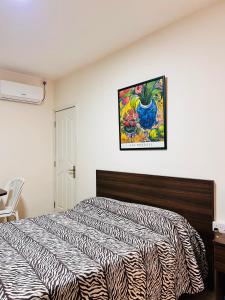 a bedroom with two beds and a picture on the wall at Manuel's Apartment in Port Louis