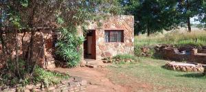 a small stone house with a window and a door at Joy River Backpackers in Moremela