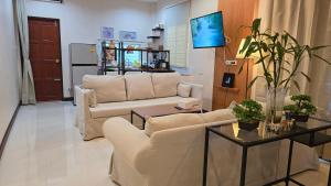 a living room with two couches and a table at VK House Rawai, Phuket in Rawai Beach