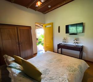 a bedroom with a bed and a television on the wall at FINCA HOTEL DON JULIO in Santa Rosa de Cabal