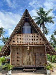 a thatched hut with palm trees in the background at Villa Fria private beach cottage in San Vicente