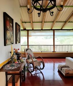 a living room with a table and chairs and a large window at FINCA HOTEL DON JULIO in Santa Rosa de Cabal