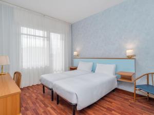 un dormitorio con una cama grande blanca y una ventana en B&B HOTEL Riviera Celle Ligure, en Celle Ligure