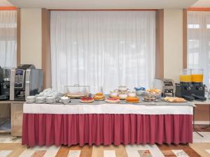 una mesa con un montón de comida encima en B&B HOTEL Riviera Celle Ligure, en Celle Ligure