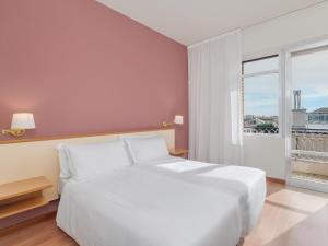 una cama blanca en una habitación con ventana en B&B HOTEL Riviera Celle Ligure, en Celle Ligure