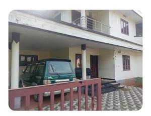 a green van parked in front of a house at Dream Home in Irimbranallūr